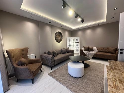 a living room with a couch and chairs and a table at Nazlipart in Bostancı