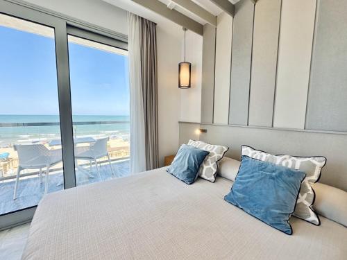 a bedroom with a bed with a view of the beach at Hotel Apartamentos Marina Luz in Chipiona