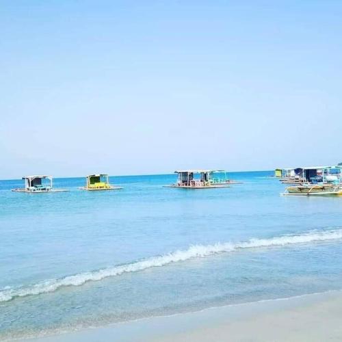 a group of boats in the water on a beach at Rudy's house in Matabungkay
