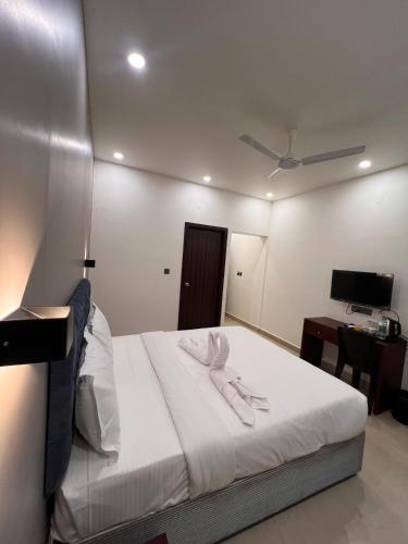 a bedroom with a bed and a desk with a computer at The Lotaz Hotel in Cochin