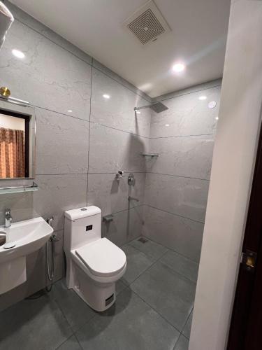 a bathroom with a toilet and a sink and a shower at The Lotaz Hotel in Cochin