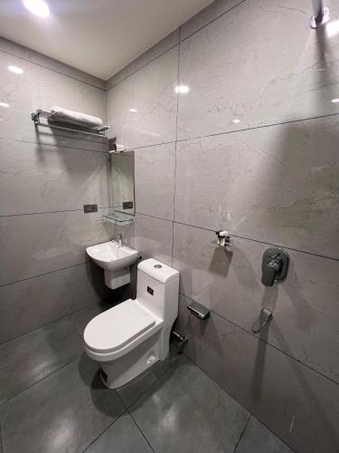 a bathroom with a toilet and a sink at The Lotaz Hotel in Cochin