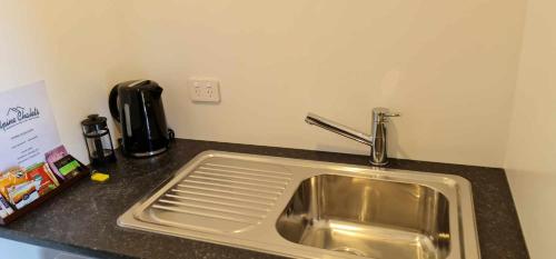 a kitchen counter with a sink and a coffee maker at Alpine Chalets in National Park