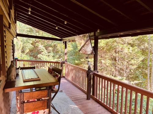 a wooden porch with a table on a deck at Tiny House, WIFI,Hot tub,Secluded in Cosby