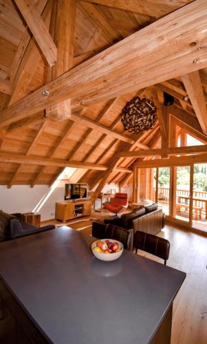 a kitchen and living room with wooden ceilings and a table at Apartment 19 in La Salle Les Alpes
