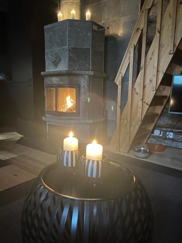 a fireplace with two candles in a room with a table at Holiday Home Rukan Ruska in Kuusamo