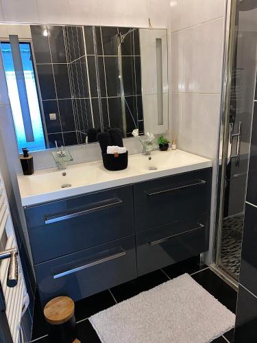 une salle de bain avec un lavabo et un miroir dans l'établissement Maison de ville COSY, à Bourg-Saint-Andéol