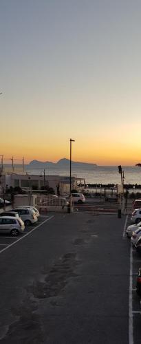 a parking lot with cars parked in front of the ocean at GIOIA Holiday Home in Torre del Greco