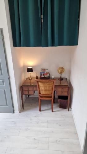 a desk with a chair and a table with a lamp at LE CHATEL BOURGEOIS in Appoigny