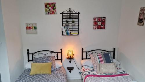 a bedroom with two beds with pillows and a lamp at LE CHATEL BOURGEOIS in Appoigny