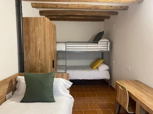 a small room with two bunk beds and a table at Apartament2 Ca la Maru amb jacuzzi comunitari in Sant Antolí i Vilanova