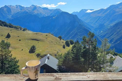 - une tasse de café assise sur une corniche en bois avec des montagnes dans l'établissement Un studio à Villard-Reculas, à Villard-Reculas