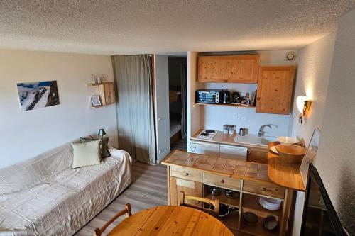 un petit salon avec un canapé et une cuisine dans l'établissement Un studio à Villard-Reculas, à Villard-Reculas