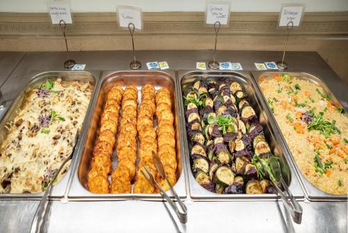 a display case with different types of food in trays at Termál Hotel Vesta in Tápiószecső