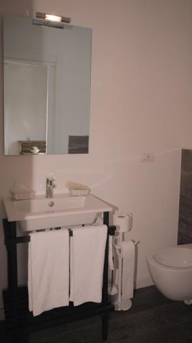 a bathroom with a sink and a toilet and a mirror at Casa Remussi in Treiso