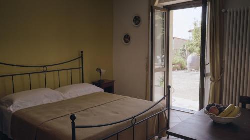 a bedroom with a bed and a sliding glass door at Casa Remussi in Treiso