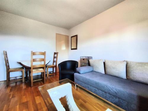 un salon avec un canapé et une table dans l'établissement Appartement cosy près des pistes avec balcon et parking - FR-1-592-69, à Bolquère-Pyrénées 2000