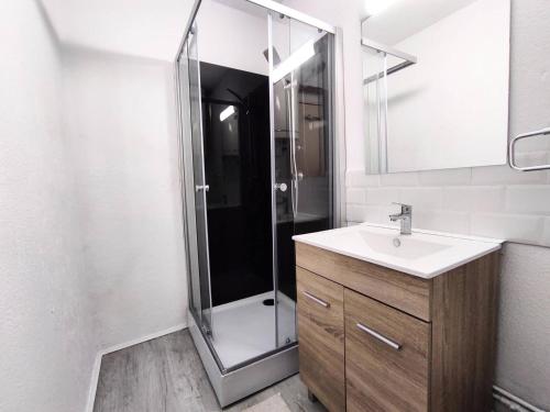 une salle de bain avec une douche avec un lavabo et un miroir dans l'établissement Appartement cosy près des pistes avec balcon et parking - FR-1-592-69, à Bolquère-Pyrénées 2000