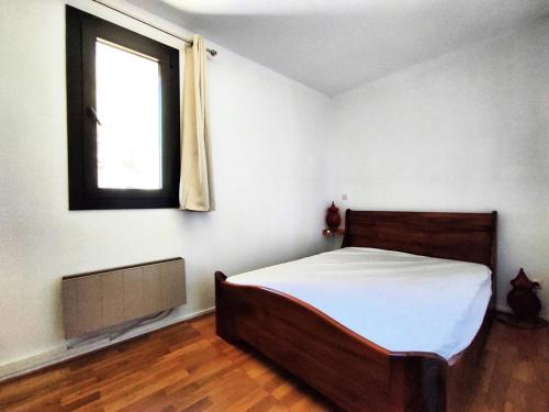 une chambre avec un lit et une fenêtre dans l'établissement Appartement cosy près des pistes avec balcon et parking - FR-1-592-69, à Bolquère-Pyrénées 2000