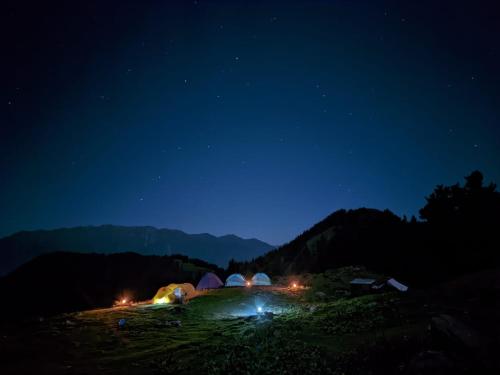a group of tents lit up at night at Outdoor Adventures Camp Pirchanasi in Muzaffarabad