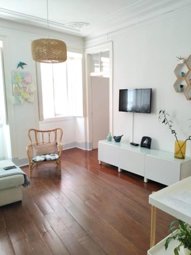 a living room with a tv on a white wall at Bird's Nest Lisbon Apartment in Lisbon