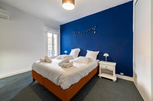 ein blaues Schlafzimmer mit einem großen Bett mit einer blauen Wand in der Unterkunft Charmant T3 climatisé proche Paris in Romainville