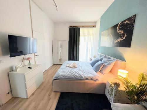 a small bedroom with a bed and a tv at Relax Suite am Waldschlösschen Dresden in Dresden