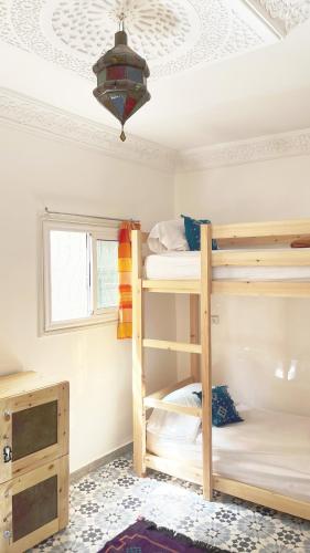 two bunk beds in a room with a ceiling at Aourir Waves Surf House in Aourir