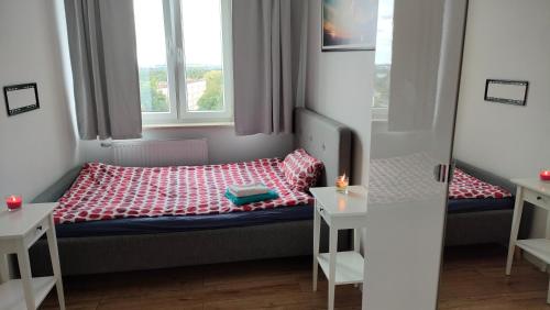 a small room with a bed and two windows at Apartament Panoramiczna "Sloneczny Balkon z Widokiem na caly Szczecin" in Szczecin