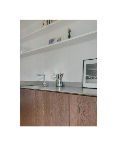 une cuisine avec un évier et des armoires en bois dans l'établissement Appartement 2 pièces Paris 20e, à Paris