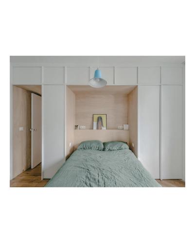 une chambre avec un lit et un mur blanc dans l'établissement Appartement 2 pièces Paris 20e, à Paris