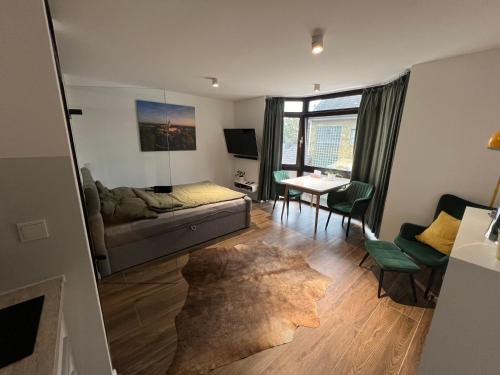 a living room with a couch and a table at Studio 7 City Lage mit Garage nähe Köln Bonn in Siegburg