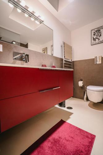a bathroom with a red vanity and a pink rug at Bitter 26 Apartment - Vinto House Collections in Nocera Superiore