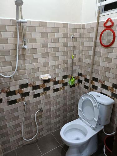 a bathroom with a white toilet and a shower at Larut Tin Homestay in Taiping