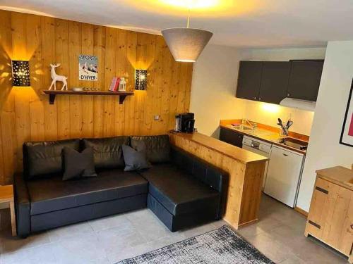 un salon avec un canapé et une cuisine dans l'établissement Chalet Champagne et Montagne C201, à Montchavin