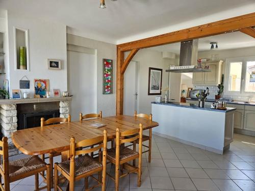 une cuisine et une salle à manger avec une table et des chaises en bois dans l'établissement Maison de vacances vue mer et port plaisance, à La Richemondière