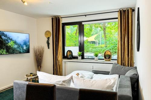 ein Wohnzimmer mit einer Couch und einem Fenster in der Unterkunft Neustadt Oase Am Park in Bremen