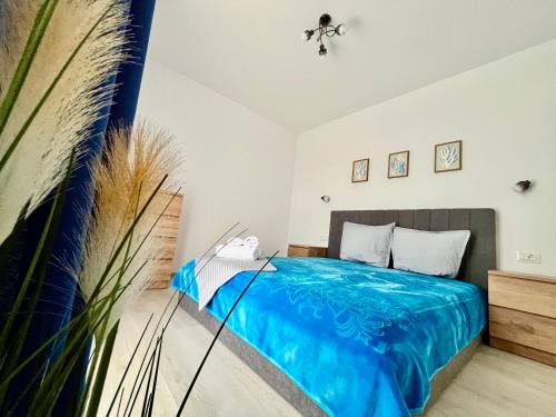 a bedroom with a bed with a blue blanket at Adam Home Ap in Fălticeni