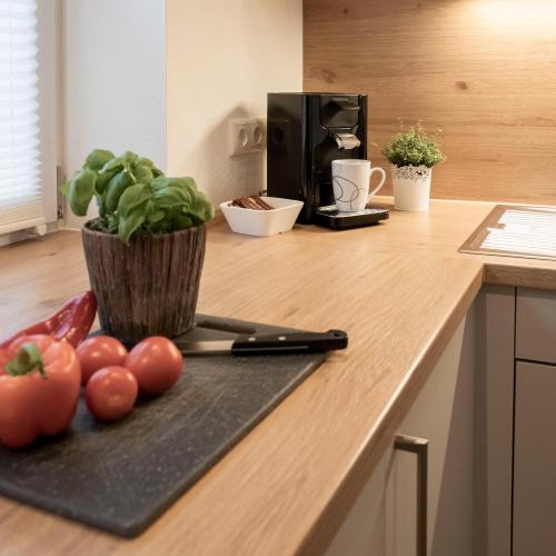 a kitchen counter with tomatoes and a potted plant on it at Ferienwohnung Magnolie in Waging am See