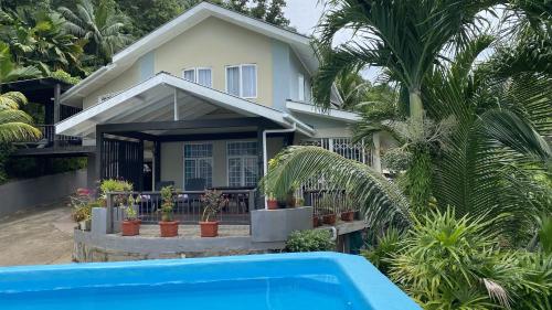 a house with a swimming pool in front of it at Stephna Residence in Anse Boileau
