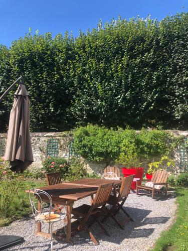 une table et des chaises en bois ainsi qu'un parasol dans l'établissement Chez Sophie, à Crépy-en-Valois