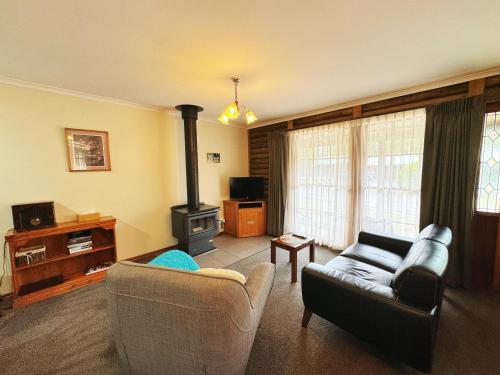 a living room with a couch and a stove at Halls Gap Log Cabins in Halls Gap