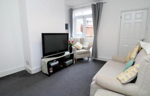a living room with a couch and a television at New Bilton House in Rugby