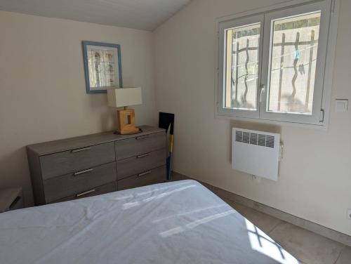 une chambre avec un lit, une commode et une fenêtre dans l'établissement villa bord de mer, à Torreilles