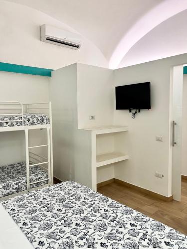 a bedroom with two bunk beds and a flat screen tv at Costantino Home in Pompei