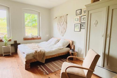 a bedroom with a bed and a chair in it at dALL in Śmidzięcino