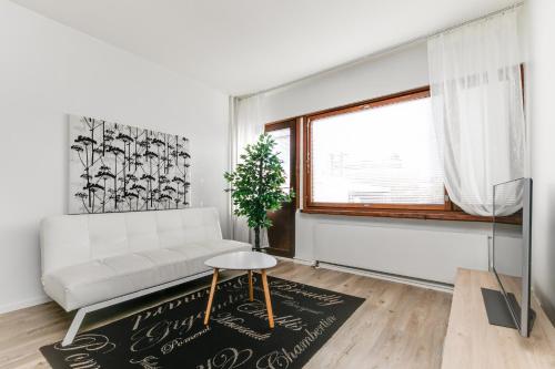a white living room with a white couch and a window at Santa's Holiday Homes in Rovaniemi