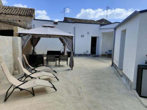 a patio with a table and chairs and an umbrella at Sicilia bedda in Custonaci