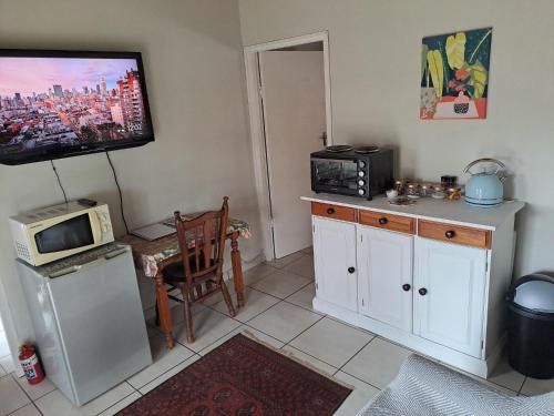 cocina con microondas y TV en la pared en Valley View, en Waterfall