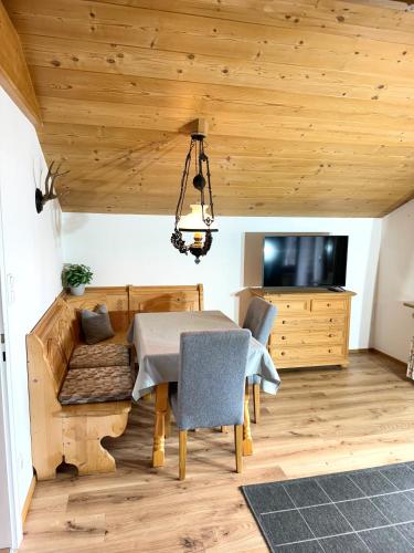 a dining room with a table and a tv at Ferienwohnung Grasegger in Farchant